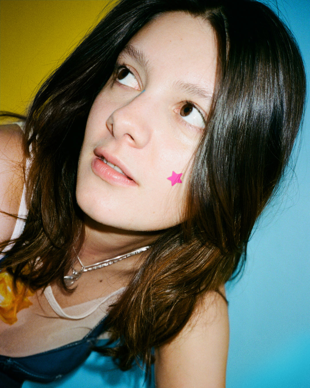 A person wearing bright Starface Hydro-Star® pimple patches on their face. Star-shaped hydrocolloid patches for spots.