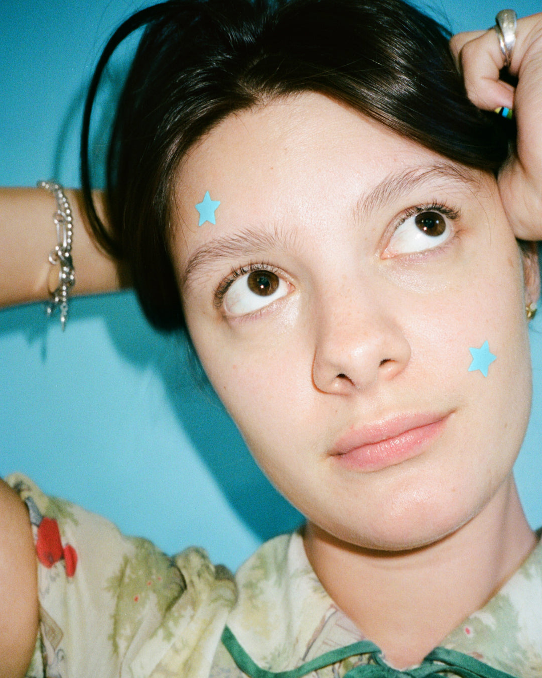 A person wearing blue Starface Hydro-Star® + Salicylic Acid patches. Star-shaped patches that shrink spots and unclog pores.