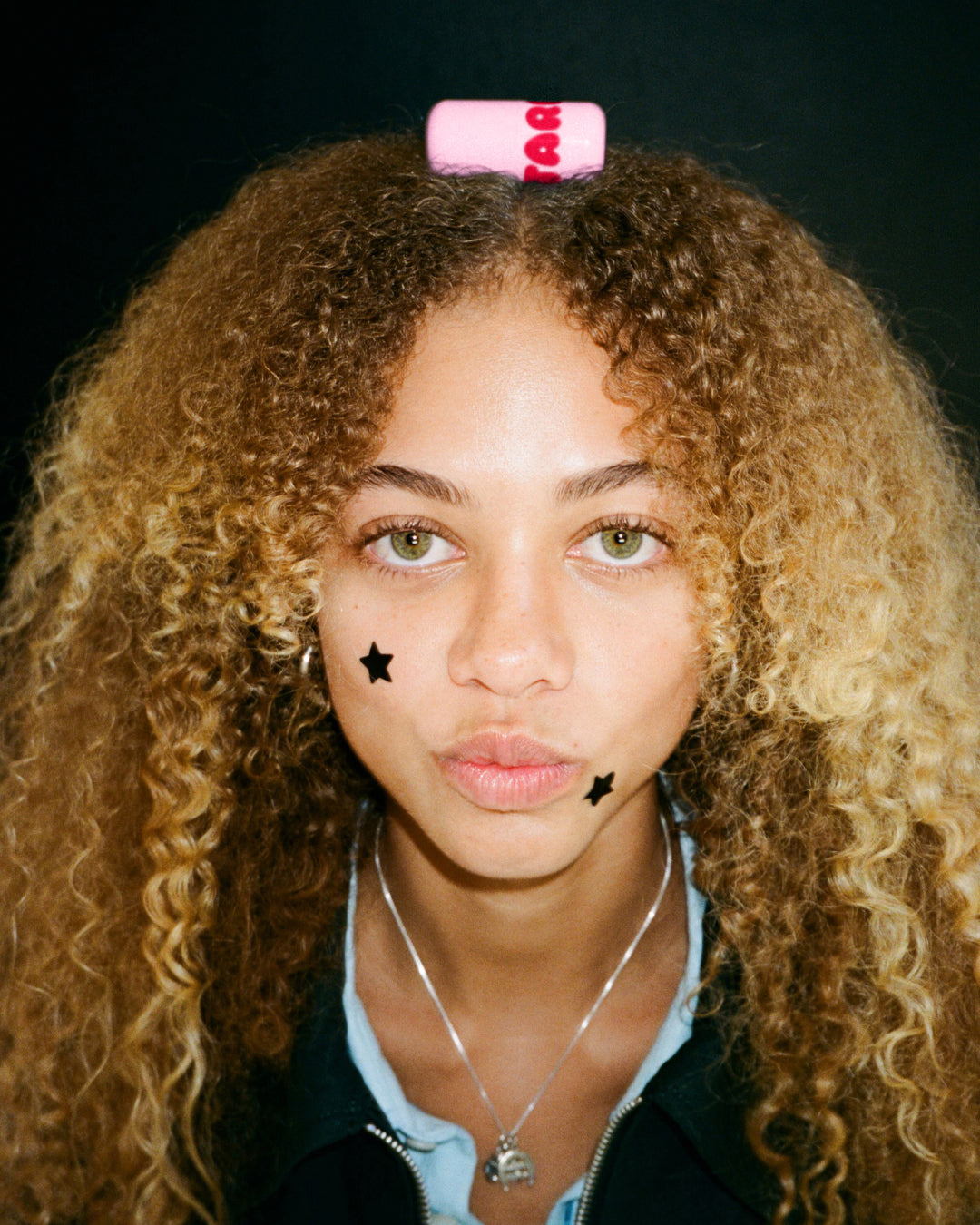 Lifestyle portrait of a person with Starface Star Balm® Cherry Charm. A sweet cherry lip balm for daily wear.