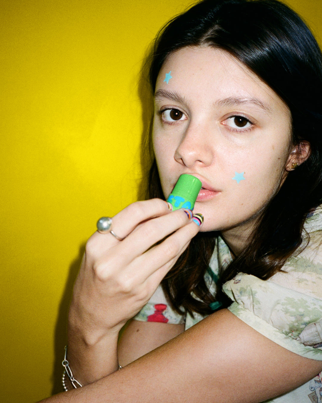 A person wears Starface Star Balm® in Coconut Blast. This creamy coconut lip balm leaves lips soft and hydrated.