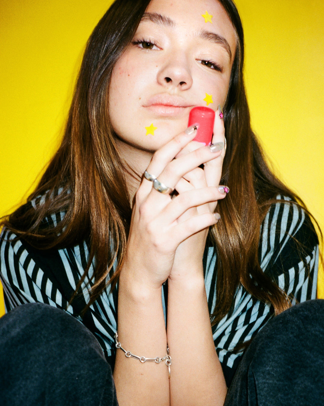 Lifestyle portrait of a person with Starface Star Balm® So Strawberry from the Fruity Balm Bundle. Sweet strawberry lip balm.