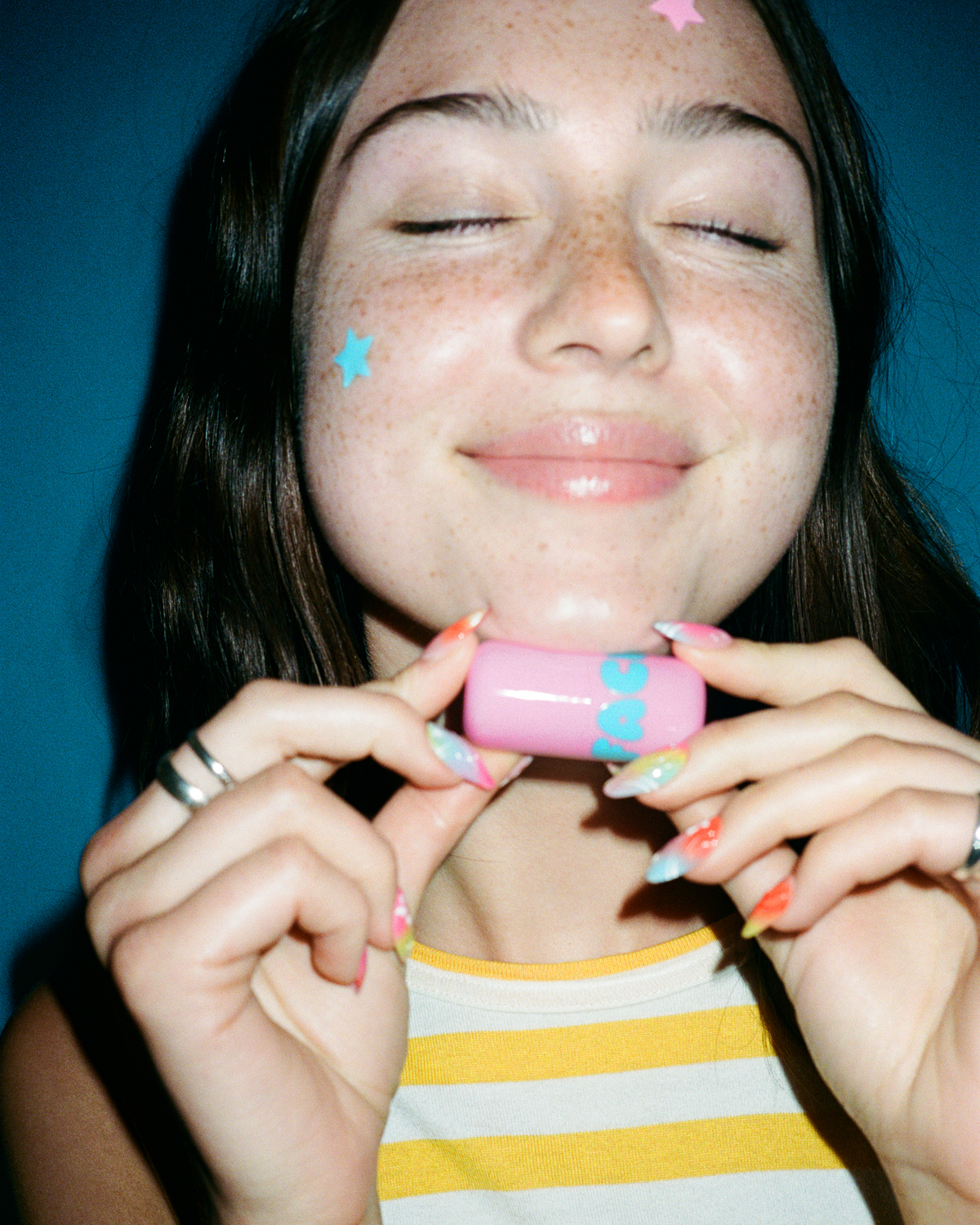 A person holds up Starface Star Balm® in Bubblegum Bliss. A sweet, fun bubblegum lip balm for hydrated lips.
