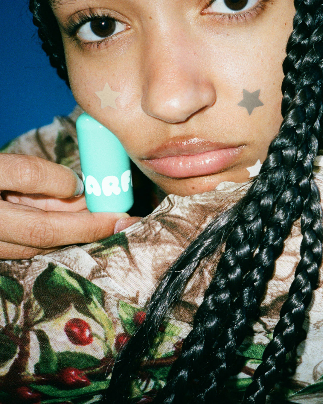 A person holds up Starface Star Balm® in Magic Mint. This fresh mint lip balm leaves lips soft and hydrated.