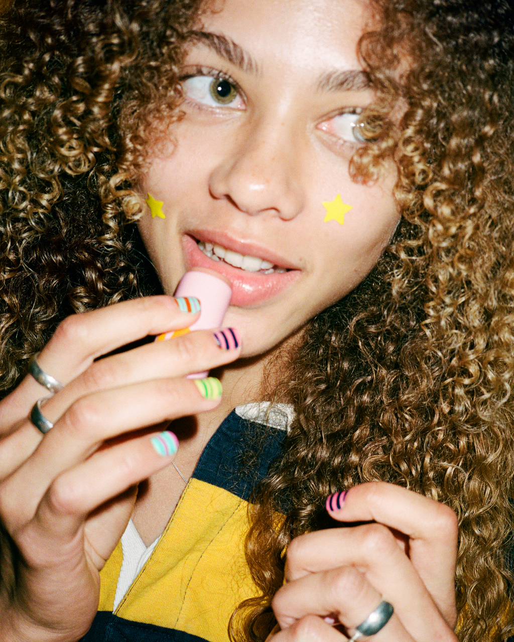 A person holds up Starface Star Balm® in Perfectly Peachy. This nectary peach lip balm leaves lips soft and hydrated.