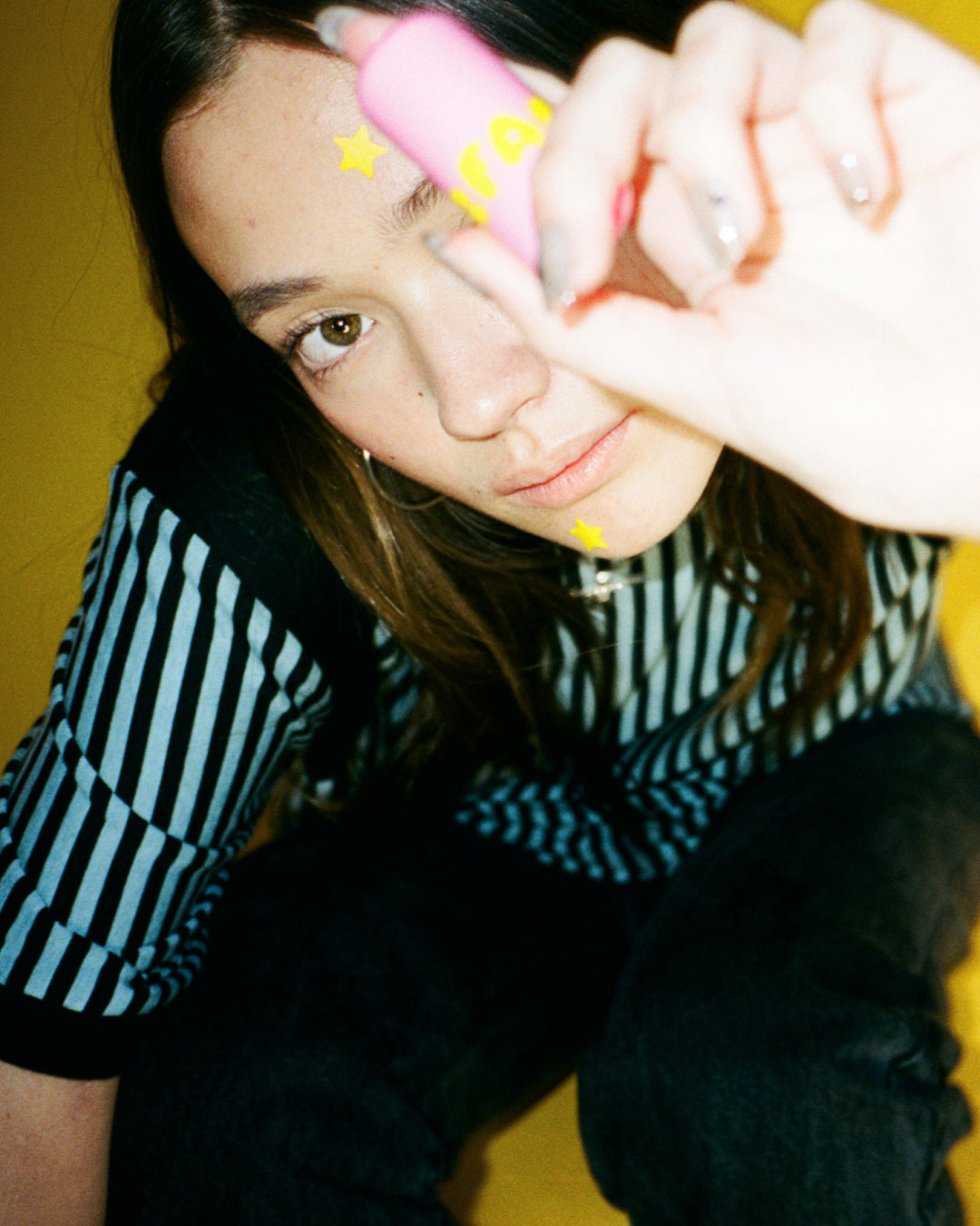 Lifestyle portrait of a person with Starface Star Balm® Starfruit. A juicy tropical lip balm for everyday wear.