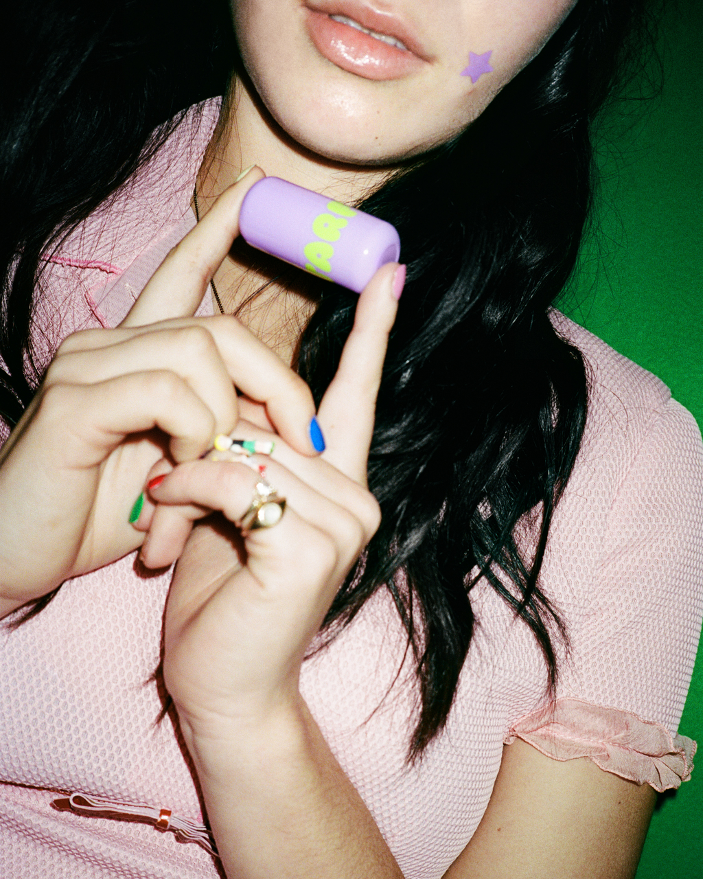 Lifestyle portrait of a person with Starface Star Balm® Super Grape. A fresh, fizzy grape lip balm for daily wear.