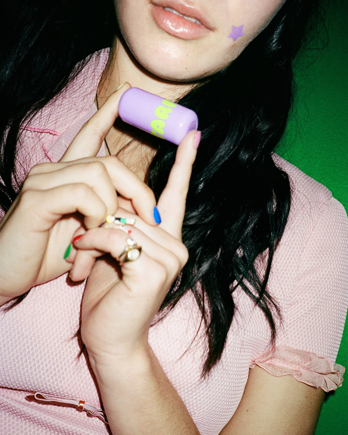Lifestyle portrait of a person with Starface Star Balm® Super Grape. A fresh, fizzy grape lip balm for daily wear.