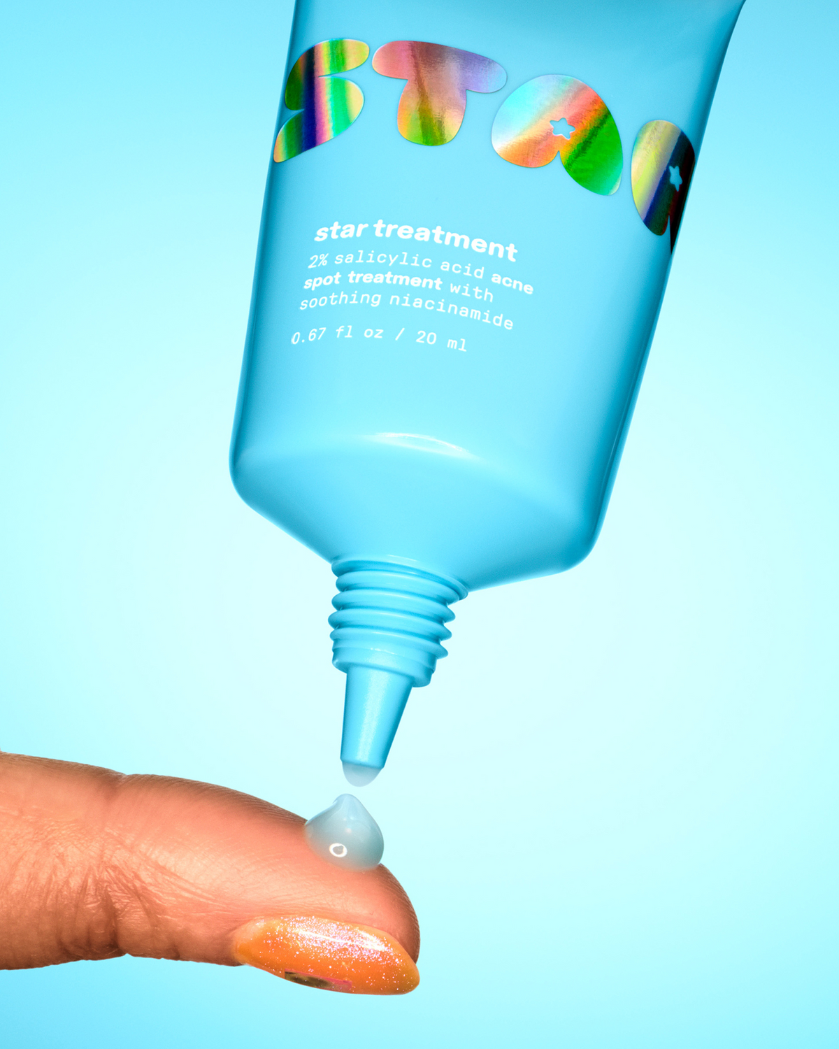 Blue-tinted Starface Star Treatment™ acne spot treatment on a fingertip. A 2% salicylic acid spot treatment that dries clear.