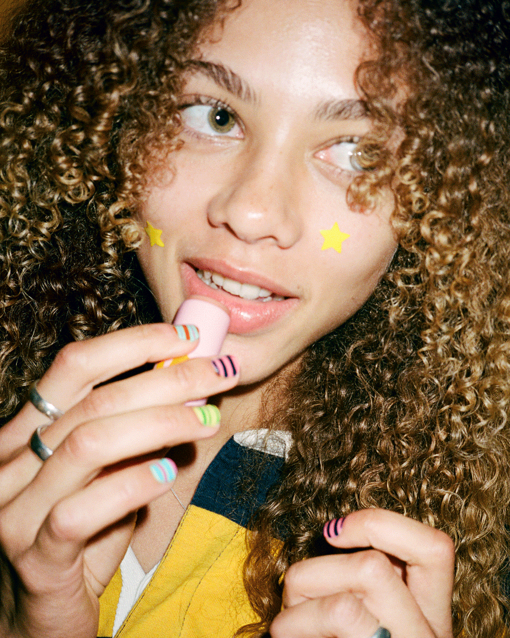 Portrait of a person with the Starface Sugar Rush Bundle of Star Balm® lip balms. Limited-edition tasty flavors.