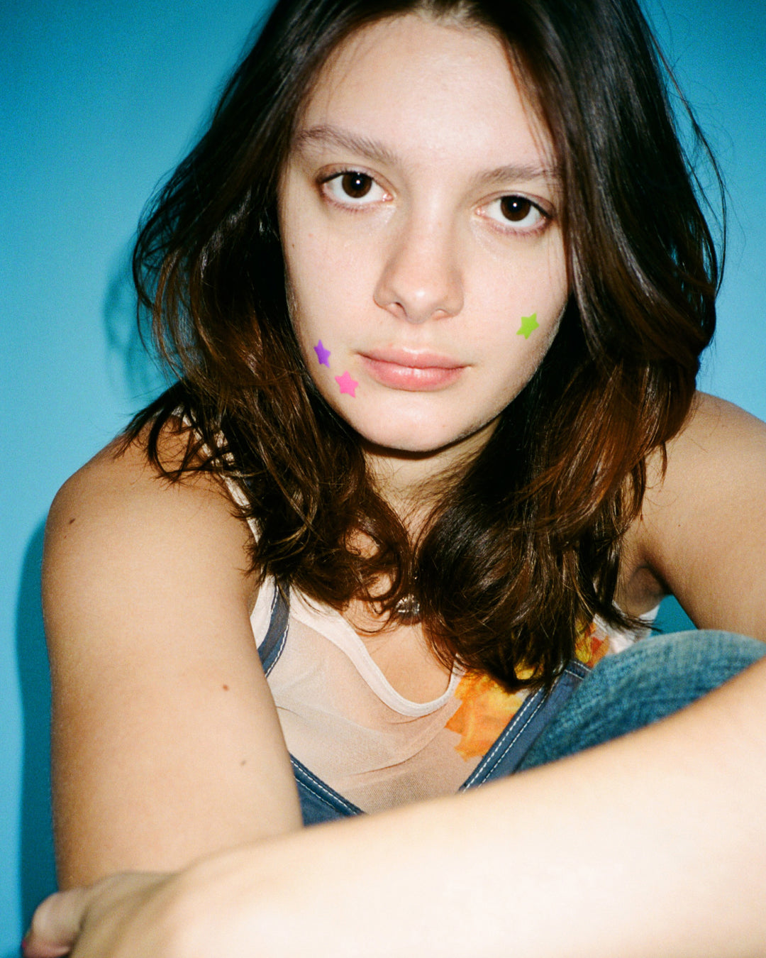 Lifestyle portrait of a person wearing tiny bright Starface Hydro-Star® patches. Extra-small star-shaped pimple patches.
