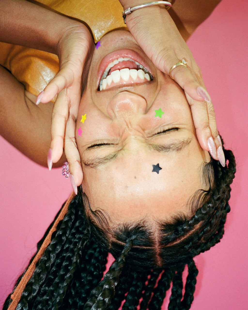 A person wearing tiny and colorful Starface Hydro-Star® pimple patches on their face. Extra-small star-shaped patches.
