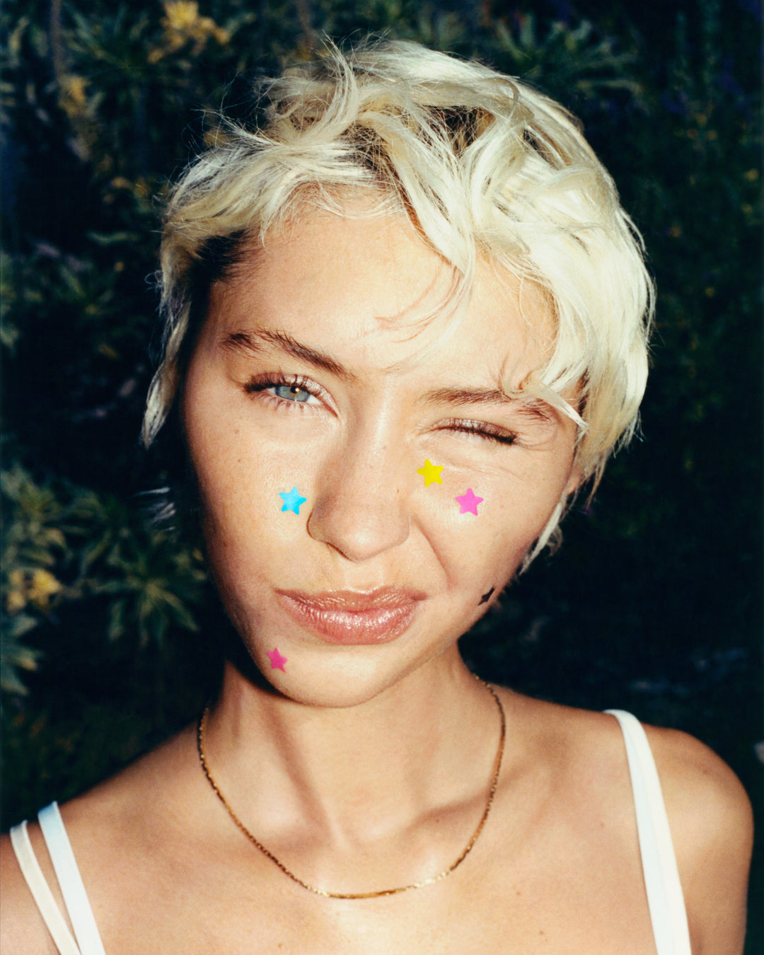 A person wearing tiny Starface Hydro-Star® pimple patches on their face. Extra-small star-shaped patches for spots.